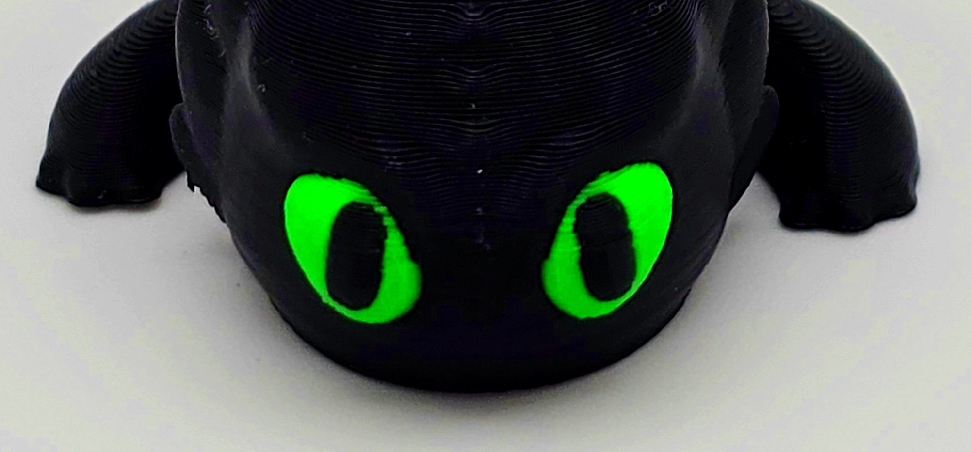 Detalle de los ojos verdes del llavero de Desdentao